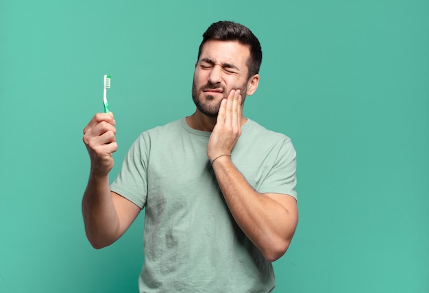 Hombre guapo joven con un cepillo de dientes.