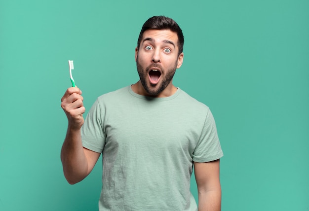 Hombre guapo joven con un cepillo de dientes.