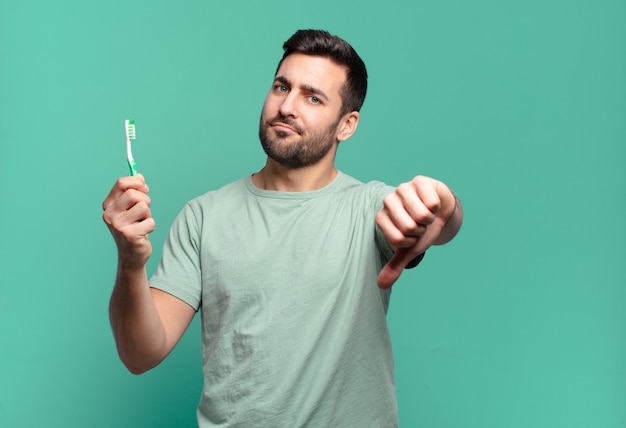 Hombre guapo joven con un cepillo de dientes.