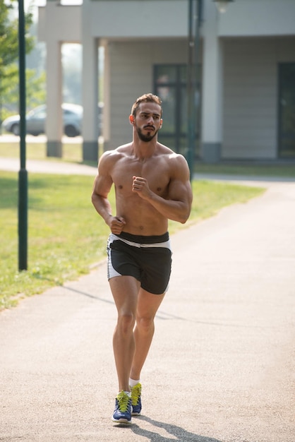 Hombre guapo joven corriendo en el parque