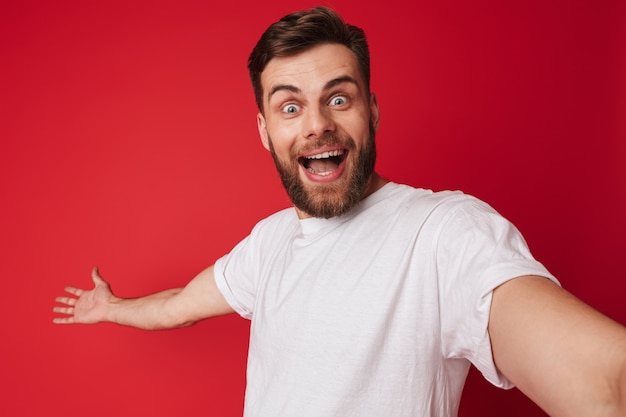 Hombre guapo joven emocionado emocional hacer una cámara de mirada selfie.