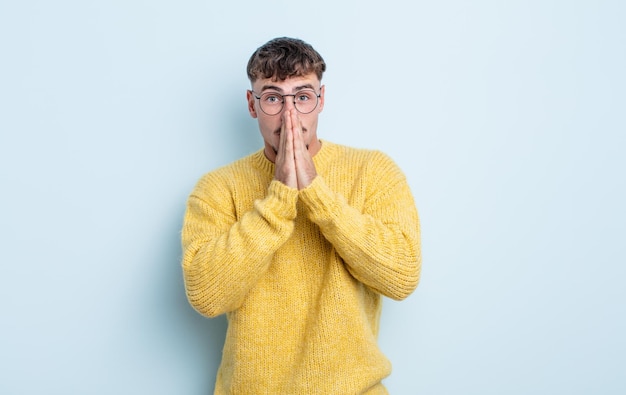 Hombre guapo joven feliz y emocionado sorprendido y asombrado cubriendo la boca con las manos riéndose con una expresión linda