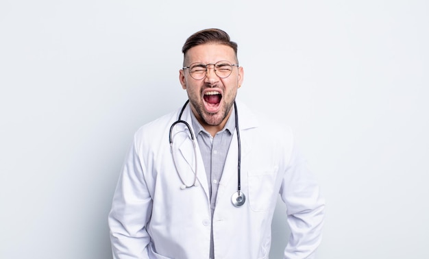 Hombre guapo joven gritando agresivamente mirando el concepto de médico muy enojado