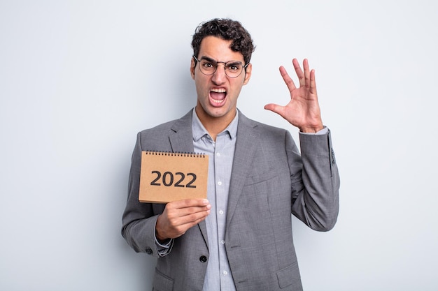 Hombre guapo joven gritando con las manos en el aire. concepto de calendario