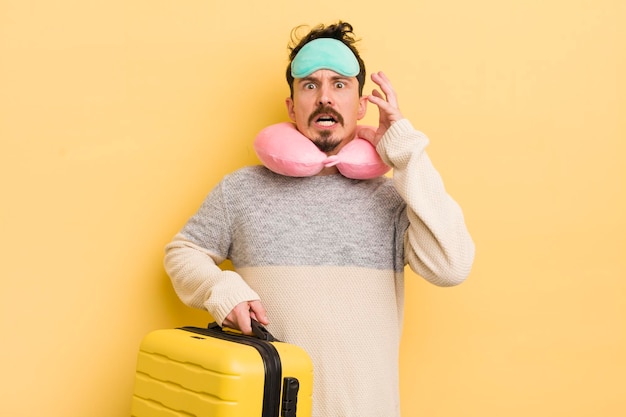 Hombre guapo joven gritando con las manos en alto en el concepto de pasajero de viaje aéreo