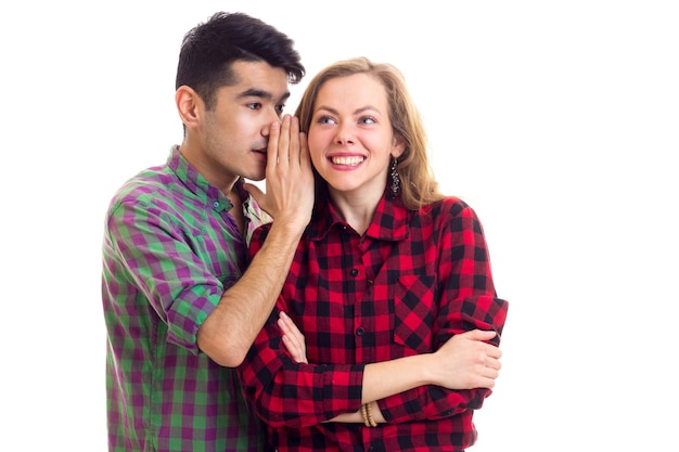 Hombre guapo joven hablando con una mujer joven sorprendida con cabello castaño largo en camisa a cuadros