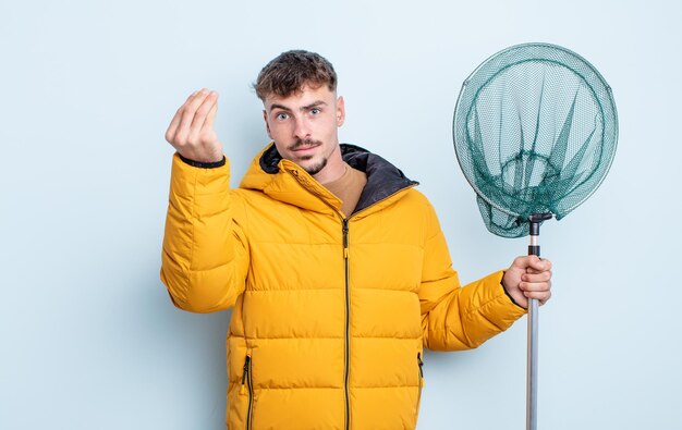 Hombre guapo joven haciendo capice o gesto de dinero diciéndote que pagues el concepto de pescador