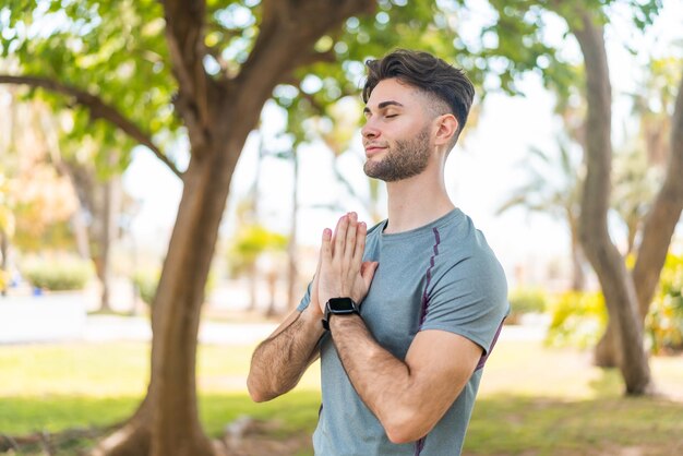 Foto hombre guapo joven haciendo yoga