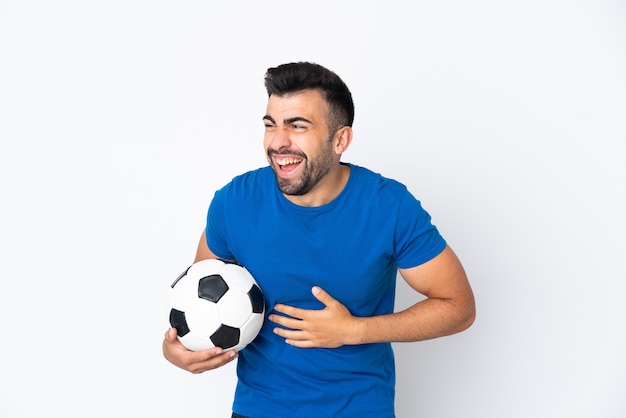 Hombre guapo joven jugador de fútbol sobre pared aislada sonriendo mucho