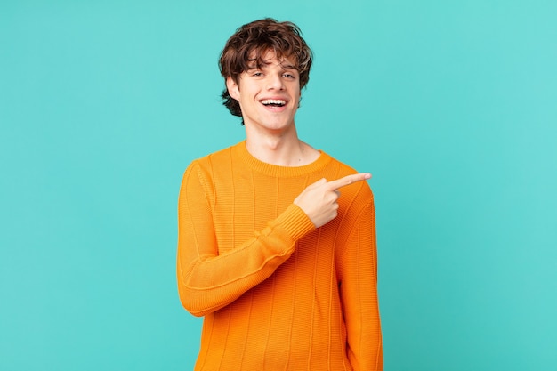 Hombre guapo joven mirando emocionado y sorprendido apuntando hacia el lado