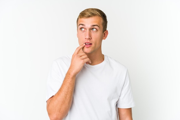 Hombre guapo joven mirando hacia los lados con expresión dudosa y escéptica