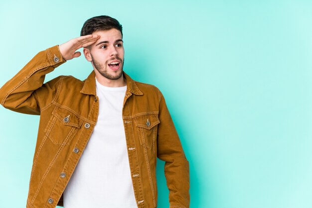 Hombre guapo joven mirando lejos manteniendo la mano en la frente.