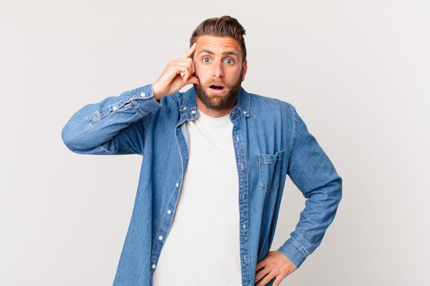 Hombre guapo joven mirando sorprendido, dándose cuenta de un nuevo pensamiento, idea o concepto