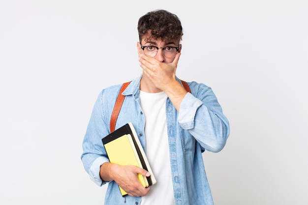 Hombre guapo joven que cubre la boca con las manos con una sorpresa. concepto de estudiante universitario