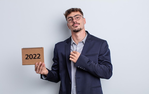 Hombre guapo joven que parece arrogante concepto de calendario positivo y orgulloso exitoso