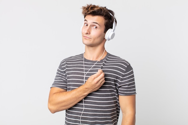 Hombre guapo joven que parece arrogante, exitoso, positivo y orgulloso. escuchando musica concepto