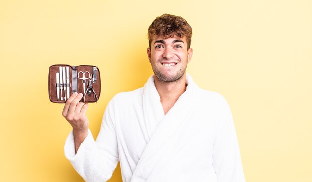 Hombre guapo joven que parece desconcertado y confundido. concepto de caja de herramientas de uñas