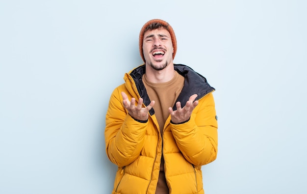 Hombre guapo joven que parece desesperado, frustrado y estresado. concepto de invierno