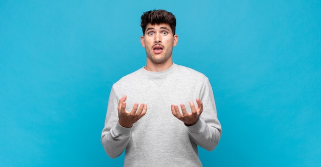 Hombre guapo joven que parece desesperado y frustrado, estresado, infeliz y molesto, gritando y gritando