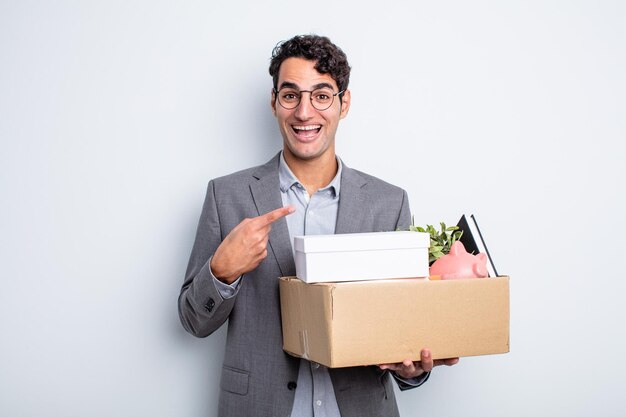 Hombre guapo joven que parece emocionado y sorprendido apuntando al concepto de despido lateral