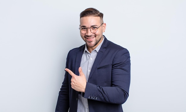 Hombre guapo joven que parece emocionado y sorprendido apuntando hacia un lado. concepto de empresario