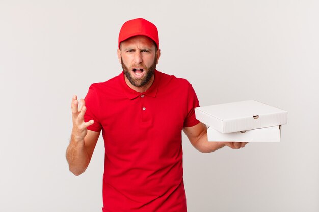 Hombre guapo joven que parece enojado, molesto y frustrado. concepto de entrega de pizza