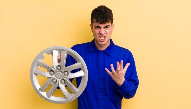 Hombre guapo joven que parece enojado molesto y frustrado concepto de reparador de automóviles