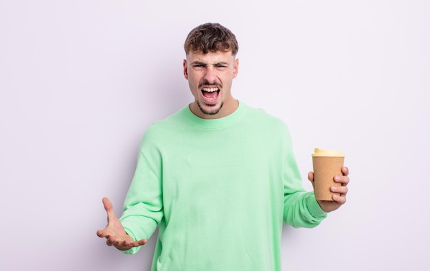 Hombre guapo joven que parece enojado molesto y frustrado para llevar el concepto de café