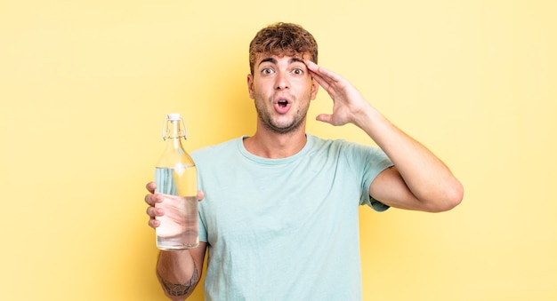 Hombre guapo joven que parece feliz, asombrado y sorprendido. concepto de agua