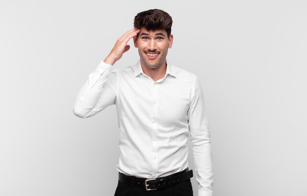 Hombre guapo joven que parece feliz, asombrado y sorprendido, sonriendo y dándose cuenta de buenas noticias increíbles e increíbles