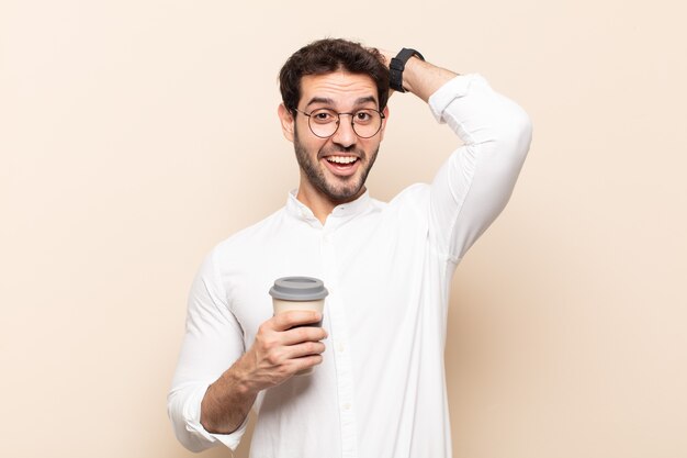 Hombre guapo joven que parece feliz, despreocupado, amigable y relajado disfrutando de la vida y el éxito, con una actitud positiva