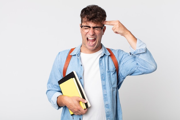 Hombre guapo joven que parece infeliz y estresado, gesto de suicidio haciendo signo de pistola. concepto de estudiante universitario