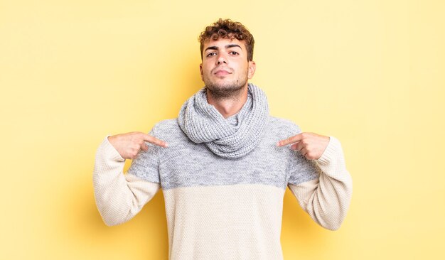 Hombre guapo joven que parece orgulloso, positivo y casual apuntando al pecho con ambas manos