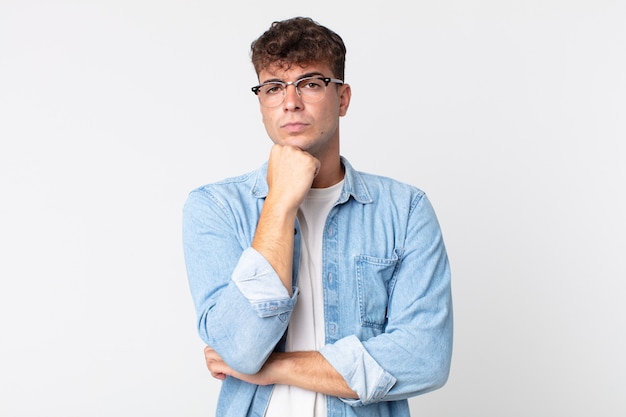 Hombre guapo joven que parece serio, confundido, inseguro y reflexivo, dudando entre opciones o elecciones