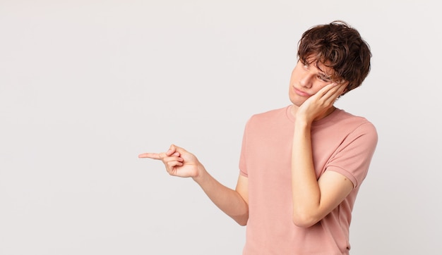 Hombre guapo joven que se siente aburrido, frustrado y con sueño después de un cansado