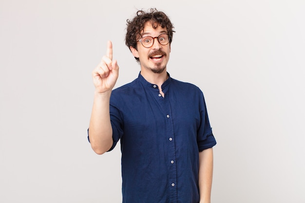 Hombre guapo joven que se siente como un genio feliz y emocionado después de darse cuenta de una idea