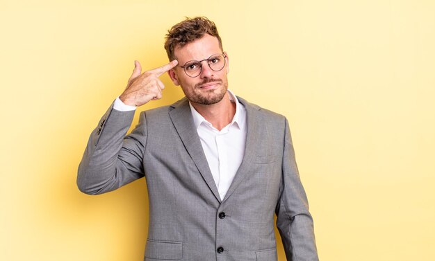 Hombre guapo joven que se siente confundido y desconcertado, mostrando que estás loco. concepto de negocio