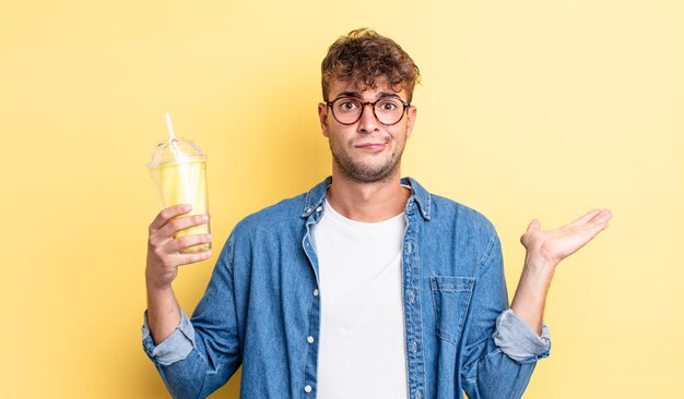 Hombre guapo joven que se siente desconcertado y confundido y dudando. concepto de batido