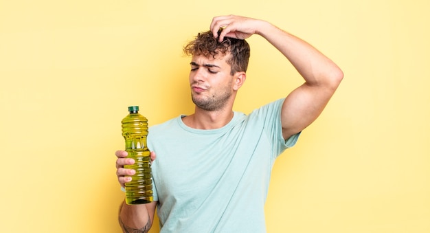 Hombre guapo joven que se siente desconcertado y confundido, rascándose la cabeza. concepto de aceite de oliva