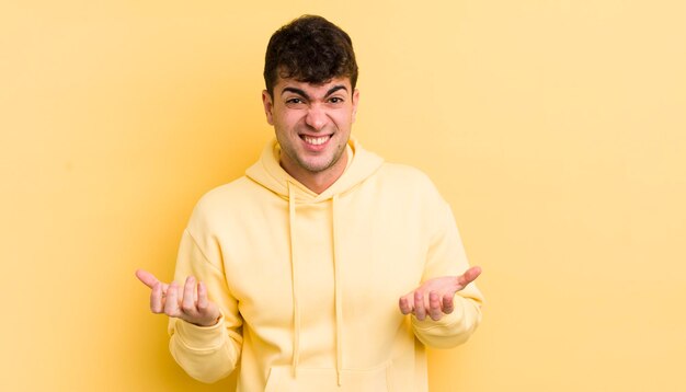 Hombre guapo joven que se siente despistado y confundido, no está seguro de qué opción u opción elegir preguntándose