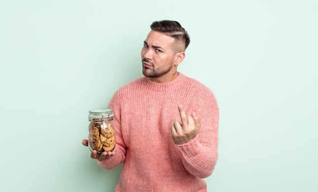 Hombre guapo joven que se siente enojado, molesto, rebelde y agresivo. concepto de botella de galletas