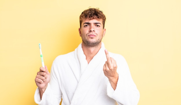 Hombre guapo joven que se siente enojado, molesto, rebelde y agresivo. concepto de cepillo de dientes