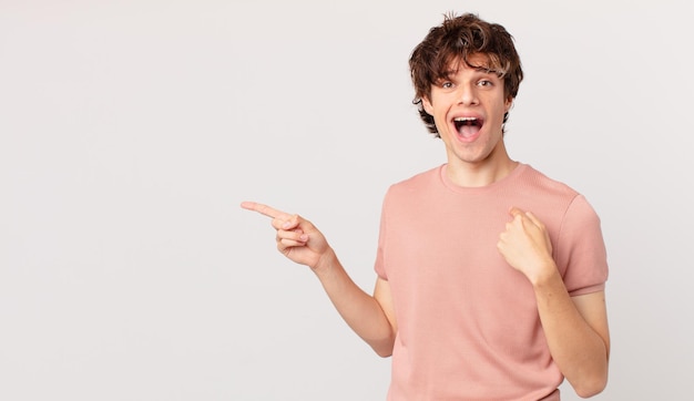 Hombre guapo joven que se siente feliz y apuntando a sí mismo con un emocionado