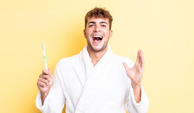 Hombre guapo joven que se siente feliz y asombrado por algo increíble. concepto de cepillo de dientes