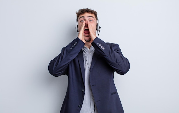 Hombre guapo joven que se siente feliz, dando un gran grito con las manos al lado de la boca. concepto de telemarketer