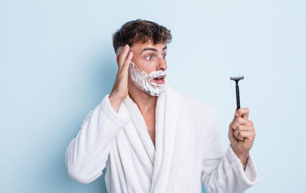 Hombre guapo joven que se siente feliz, emocionado y sorprendido. concepto de afeitado