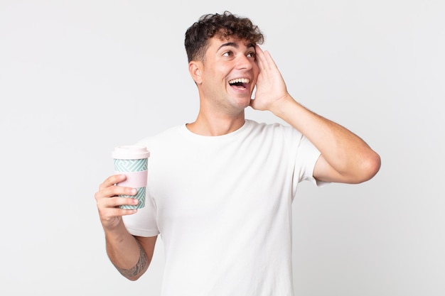 Hombre guapo joven que se siente feliz emocionado y sorprendido y sosteniendo un café para llevar