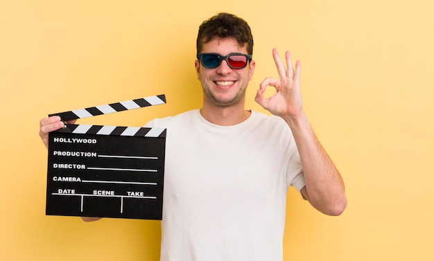 Hombre guapo joven que se siente feliz mostrando aprobación con el concepto de badajo de cine de gesto bien