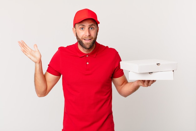 Hombre guapo joven que se siente feliz, sorprendido al darse cuenta de una solución o idea. concepto de entrega de pizza