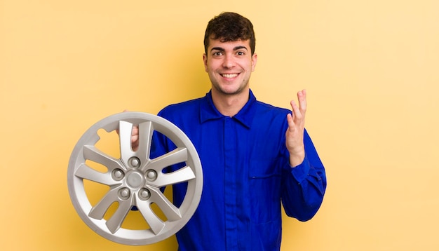 Hombre guapo joven que se siente feliz sorprendido al darse cuenta de una solución o idea del concepto de reparador de automóviles